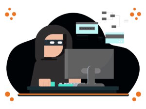A masked criminal wearing a hoodie using a computer.