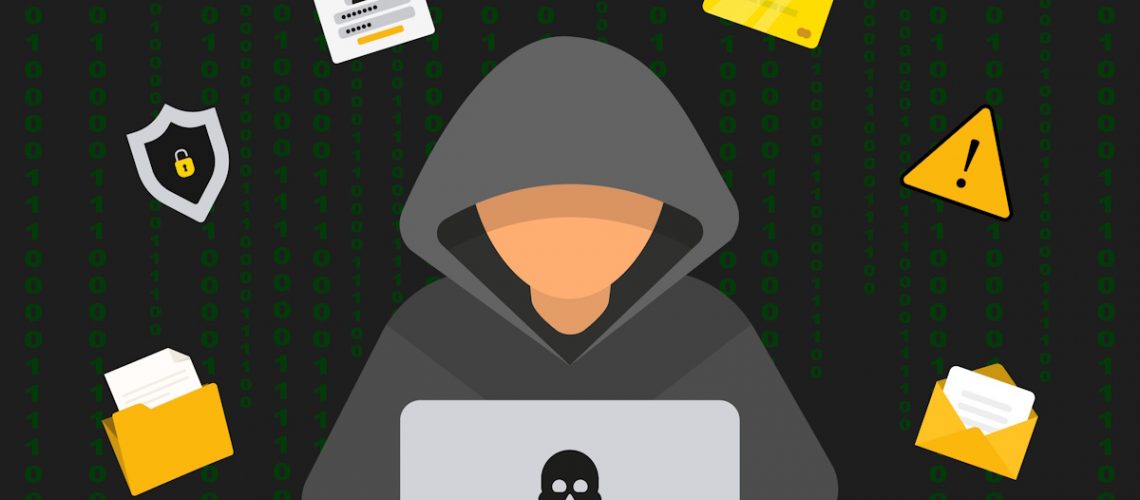 Hacker in black hood with laptop trying to start a cyber-attack.