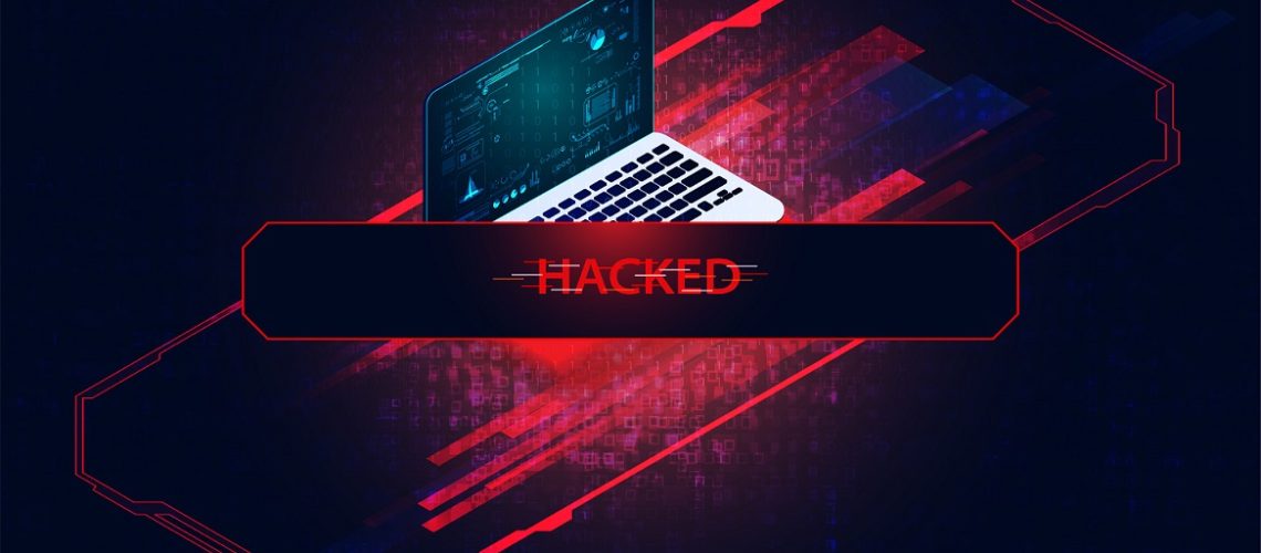 Laptop computer on red background with "Hacked" written in front