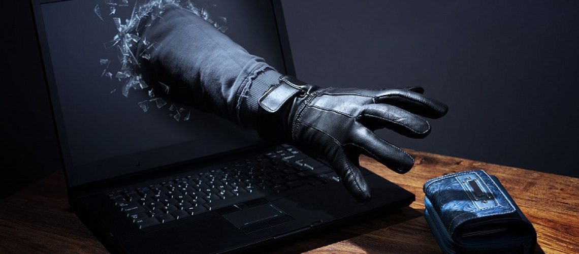 Hacker reaching out of computer screen to steal wallet