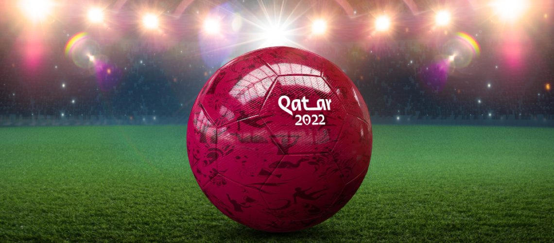 Red football with Qatar 2022 written on it